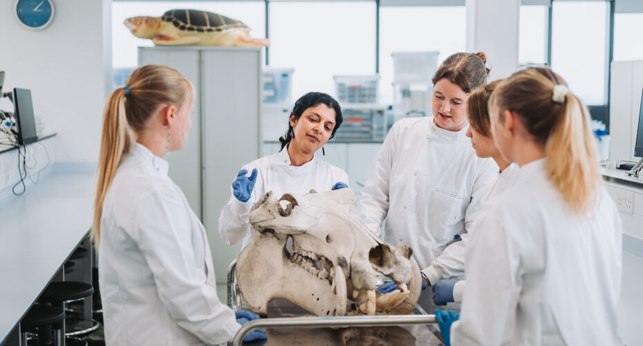 students in white coats working in lab