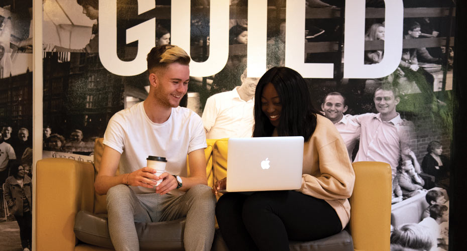 Two students working together outside the Students Guild