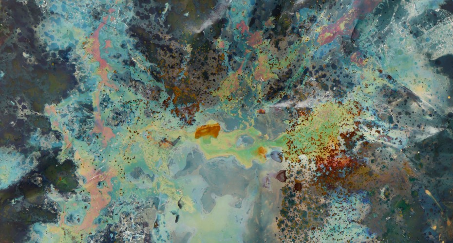 An abstract-style image featuring a dynamic mix of colors and textures. The artwork includes swirls and splatters of blue, green, orange, and black, creating a sense of depth and movement. The composition suggests an organic, almost cosmic scene, with various shades blending and contrasting throughout the piece.