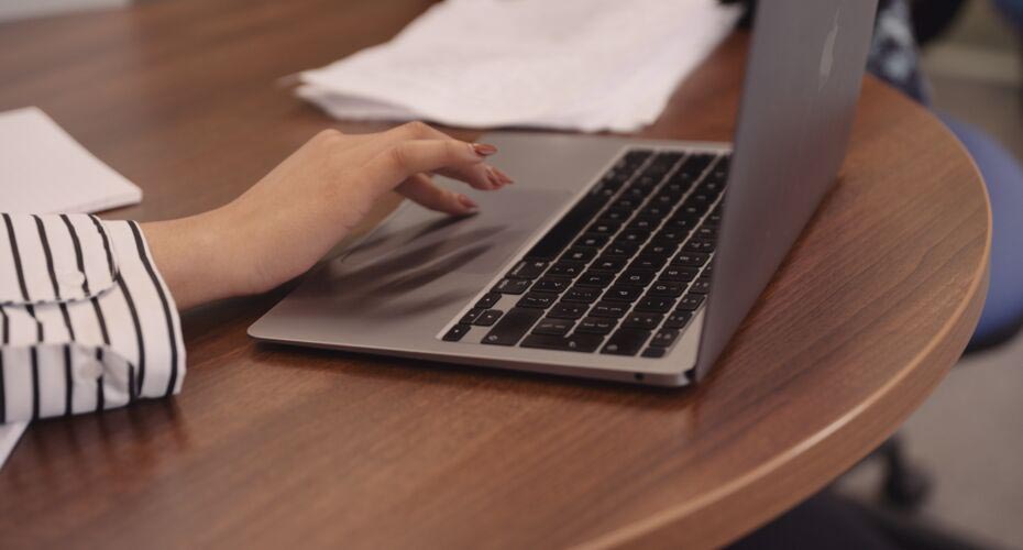 Close up of a hand typing on a laptop