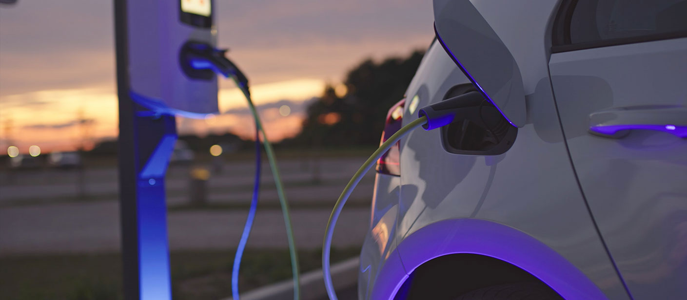a car being charged at blue energy charging station at dusk
