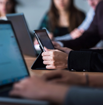 An individual using a laptop in a business meeting.
