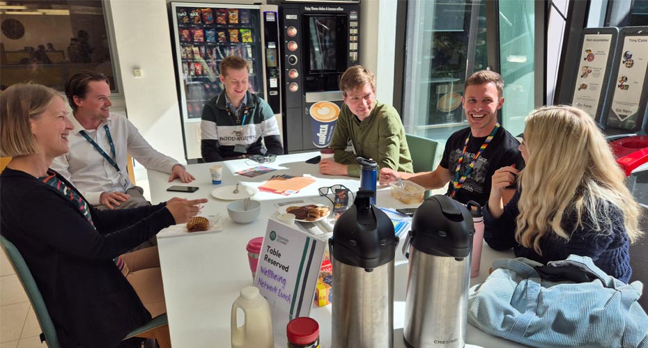 A group of smiling colleagues having a coffee together